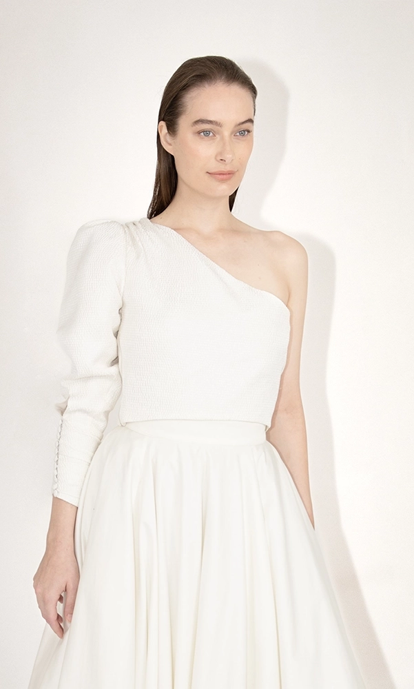 Top de mariée asymétrique sur-mesure à manche longue bouffante en soie damassée. Robes de mariée sur-mesure à Paris et boutique en ligne de robes de mariage en prêt-à-porter.